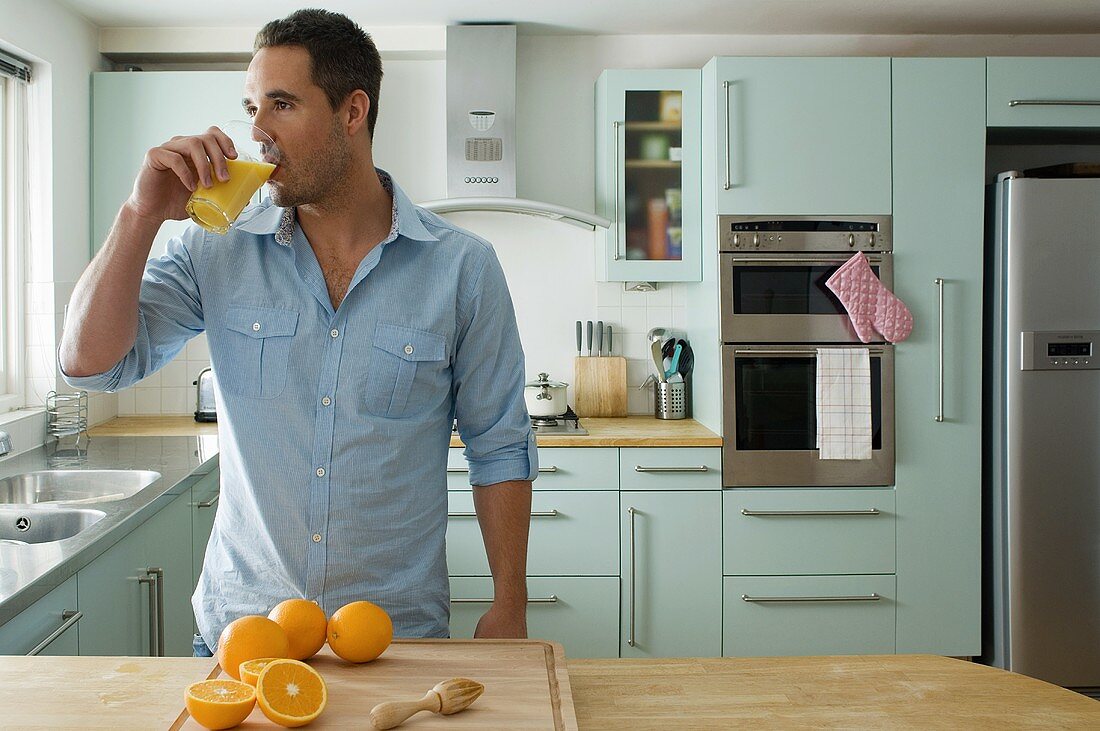 A man drinking orange juice