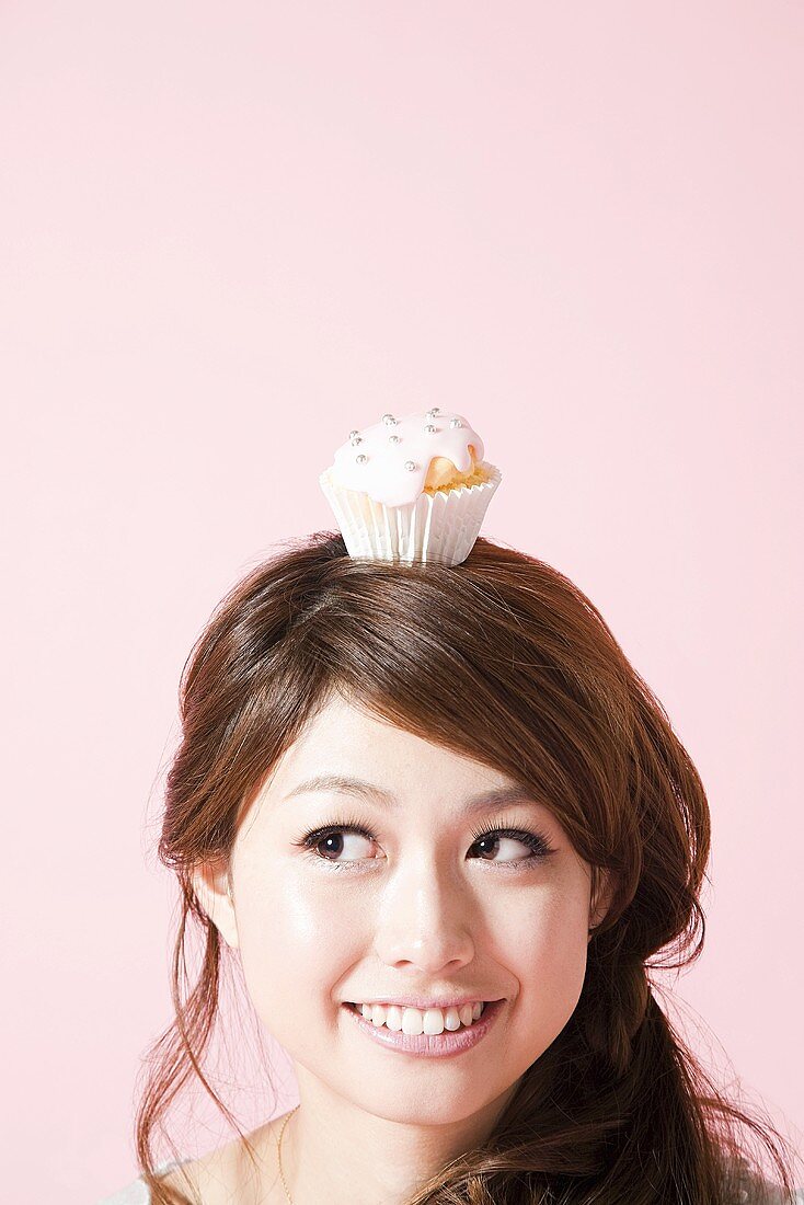 Woman with cupcake on her head