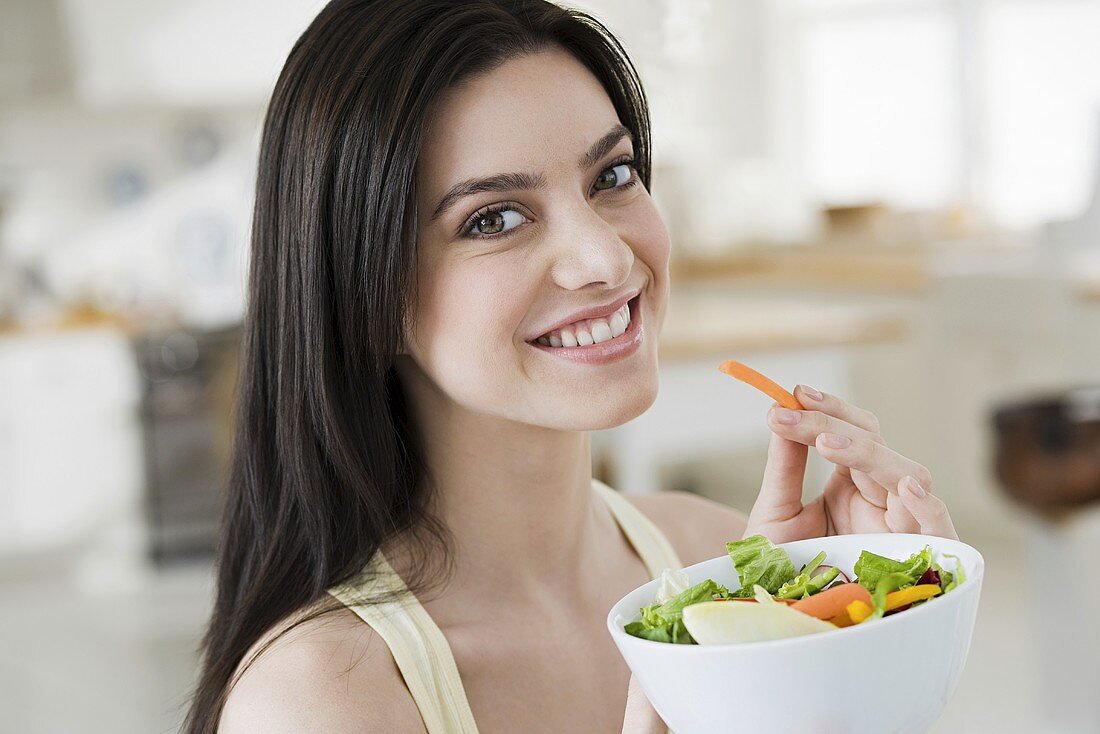 Junge Frau isst Salat