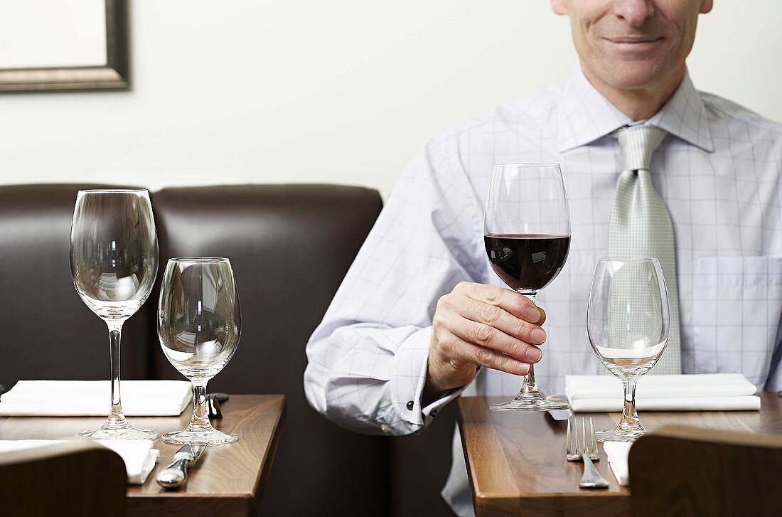 A man holding a glass of red wine