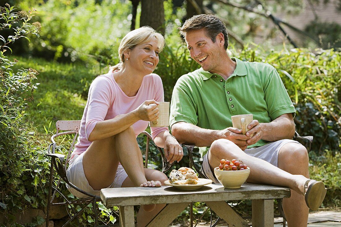 Paar mit Getränk im Garten