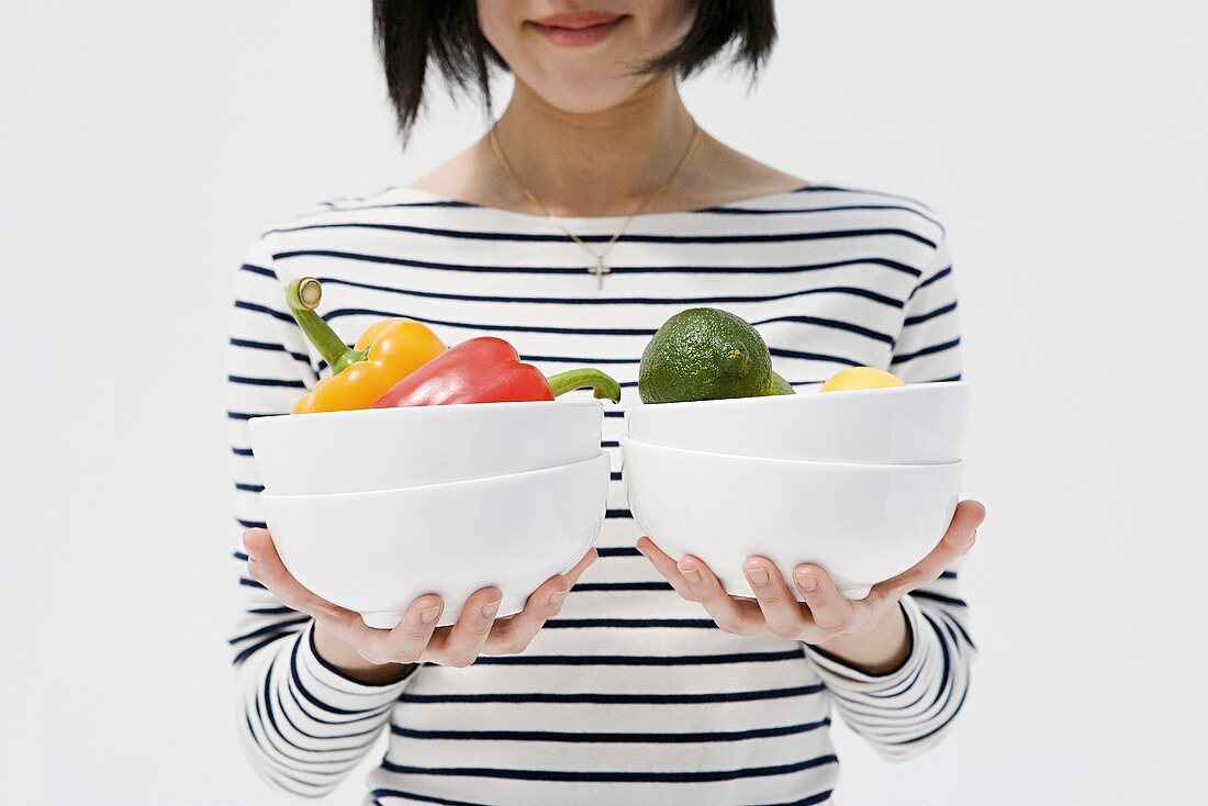 Woman holding bowls of vegetables