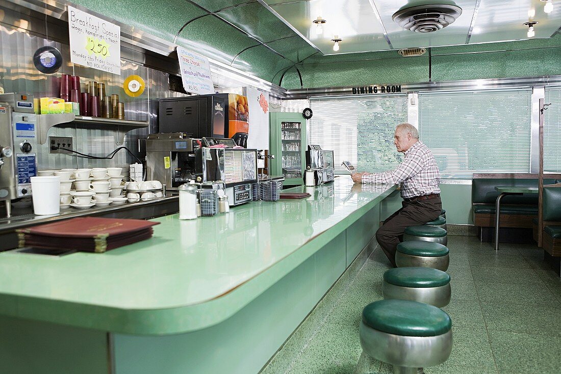 An old man sitting in a diner