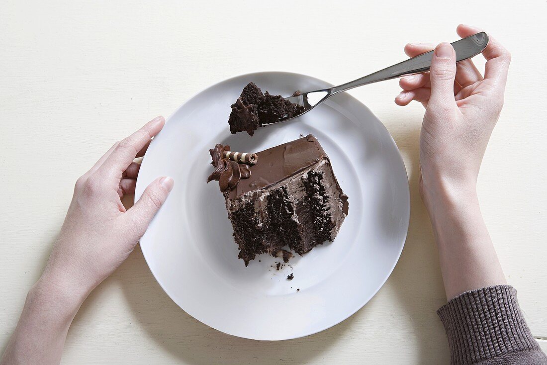 A young woman eating chocolate cake