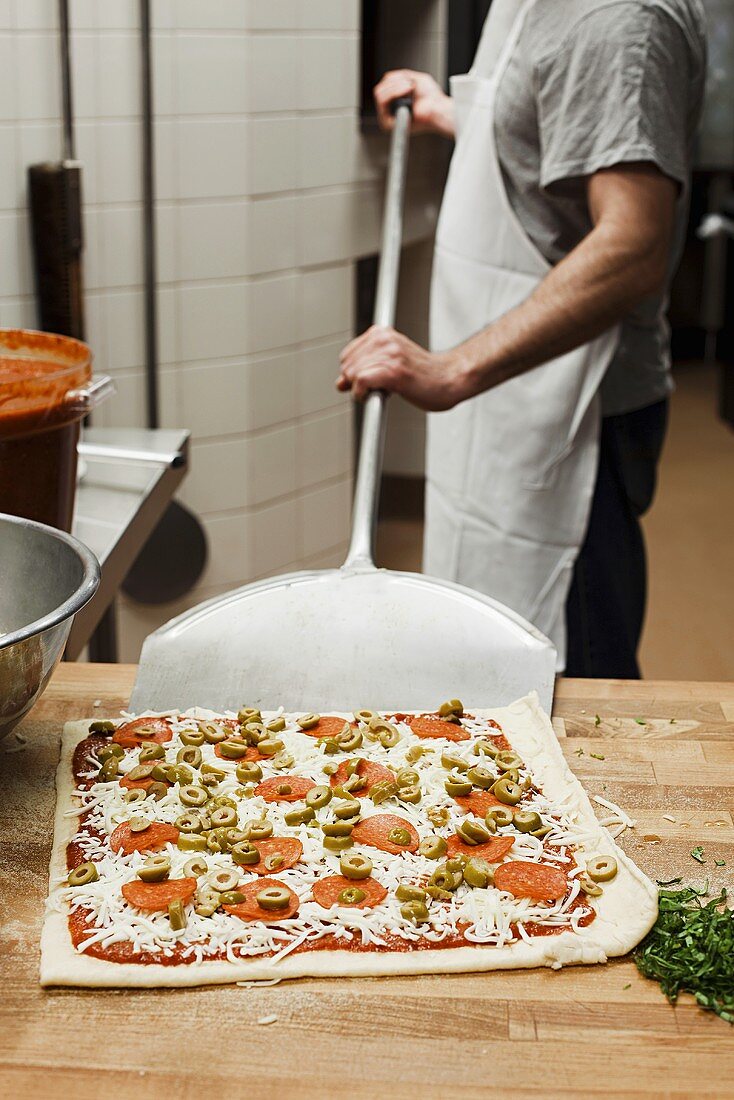 Koch macht Pizza in gastronomischer Küche