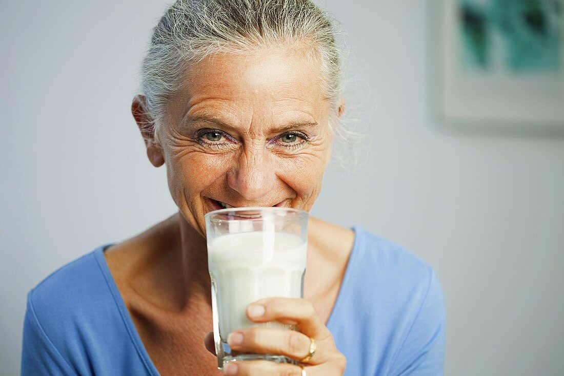 Ältere Frau trinkt ein Glas Milch