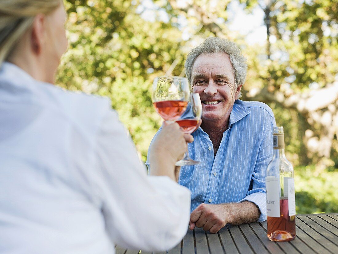 Paar stösst mit Wein im Freien an