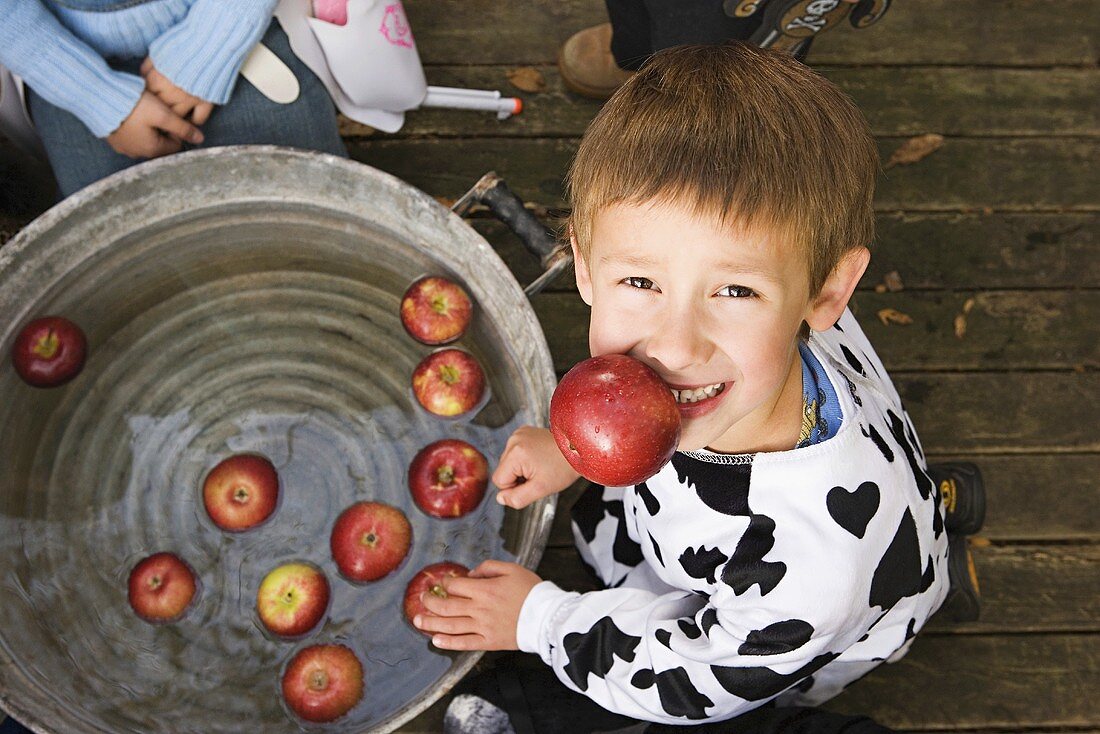 A boy with an apple in his mouth