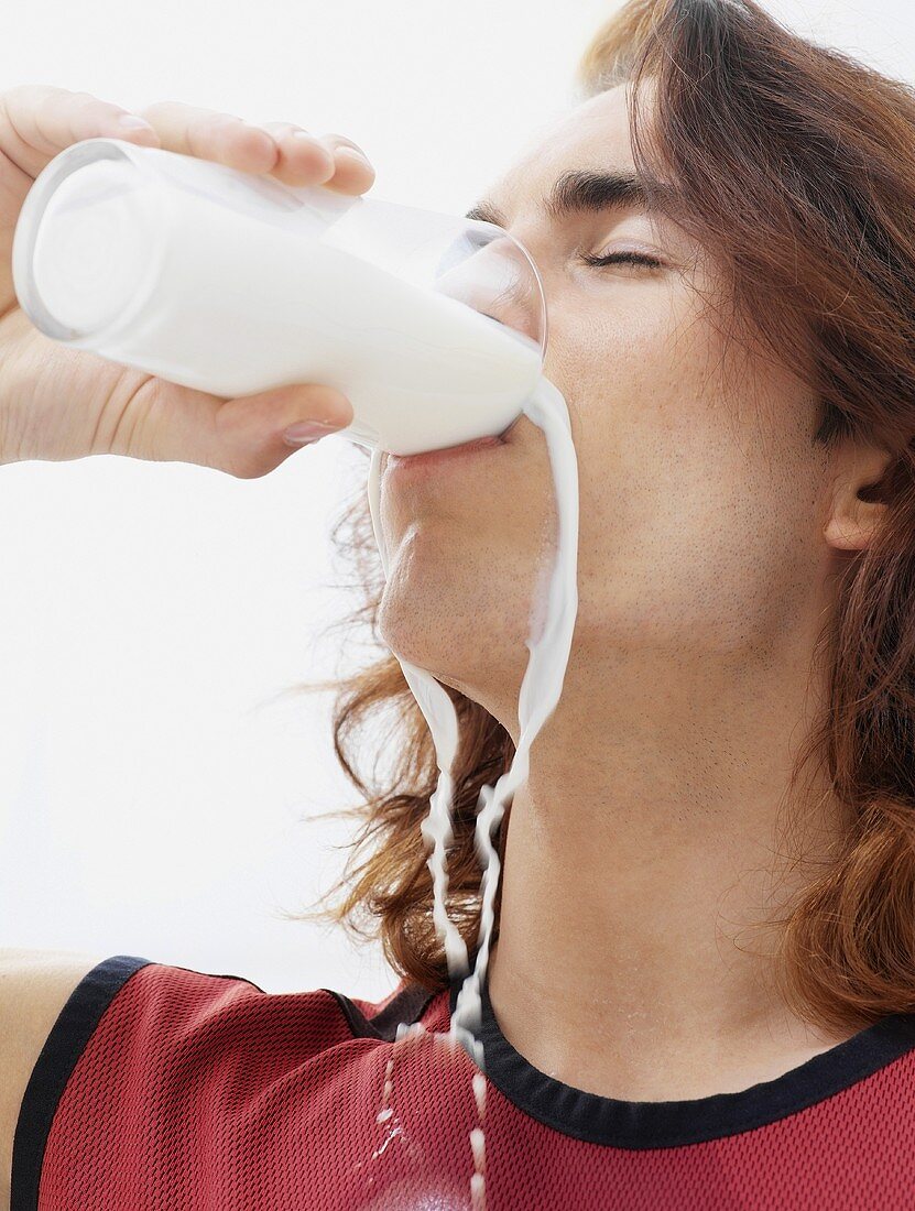 Mann trinkt ein Glas Milch überschwänglich