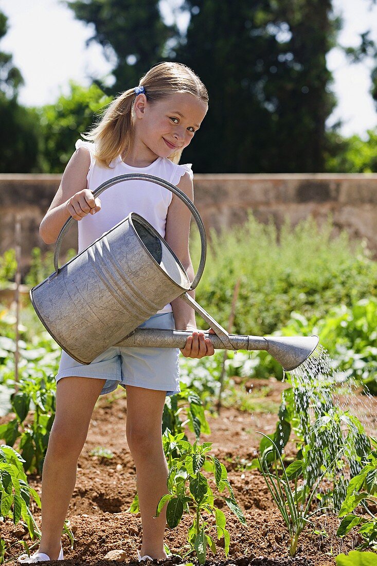 Mädchen gießt Pflanzen