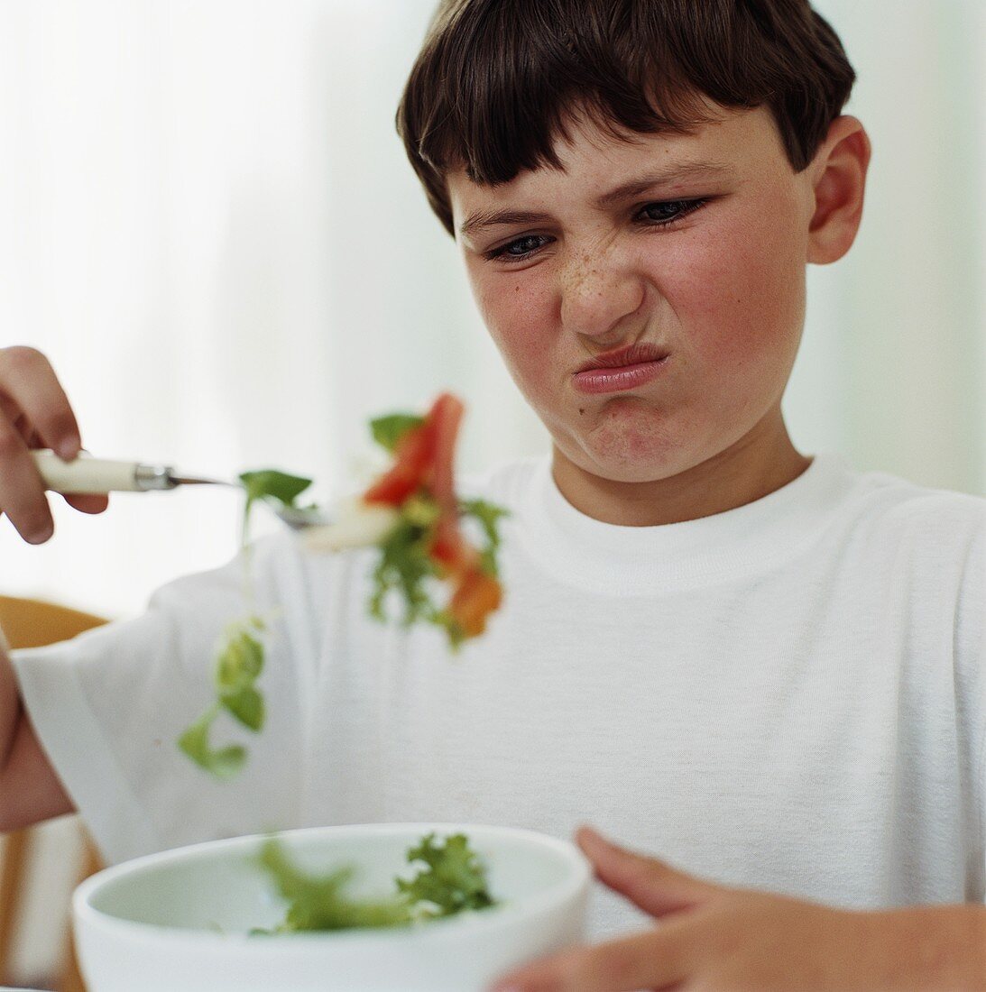 Junge ist vom Salat angewidert