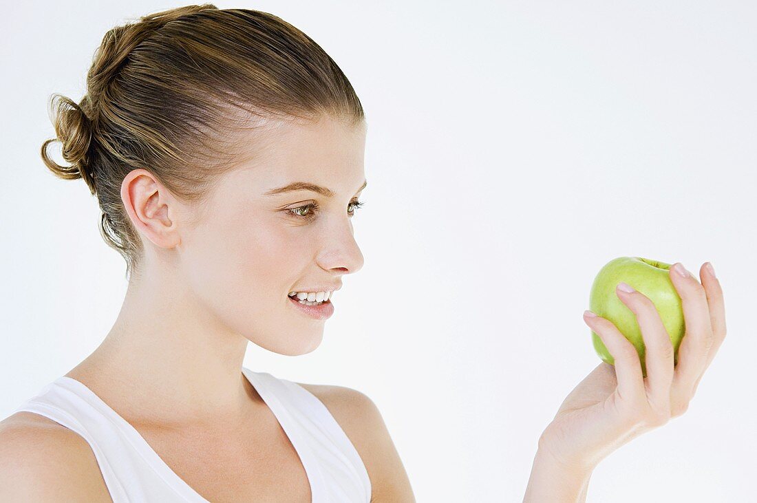 A woman holding a green apple