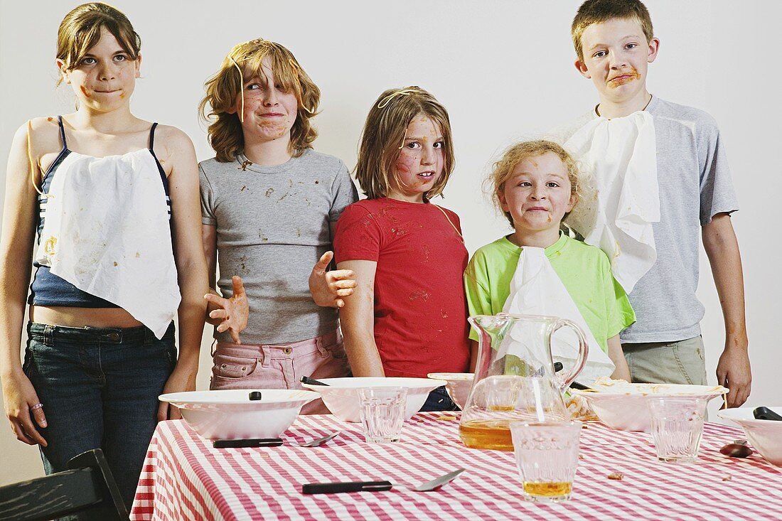 Kinder mit Essensresten auf Gesicht und Kleidung
