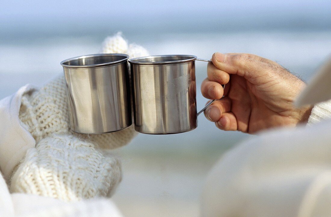 Raising a toast with two metal mugs