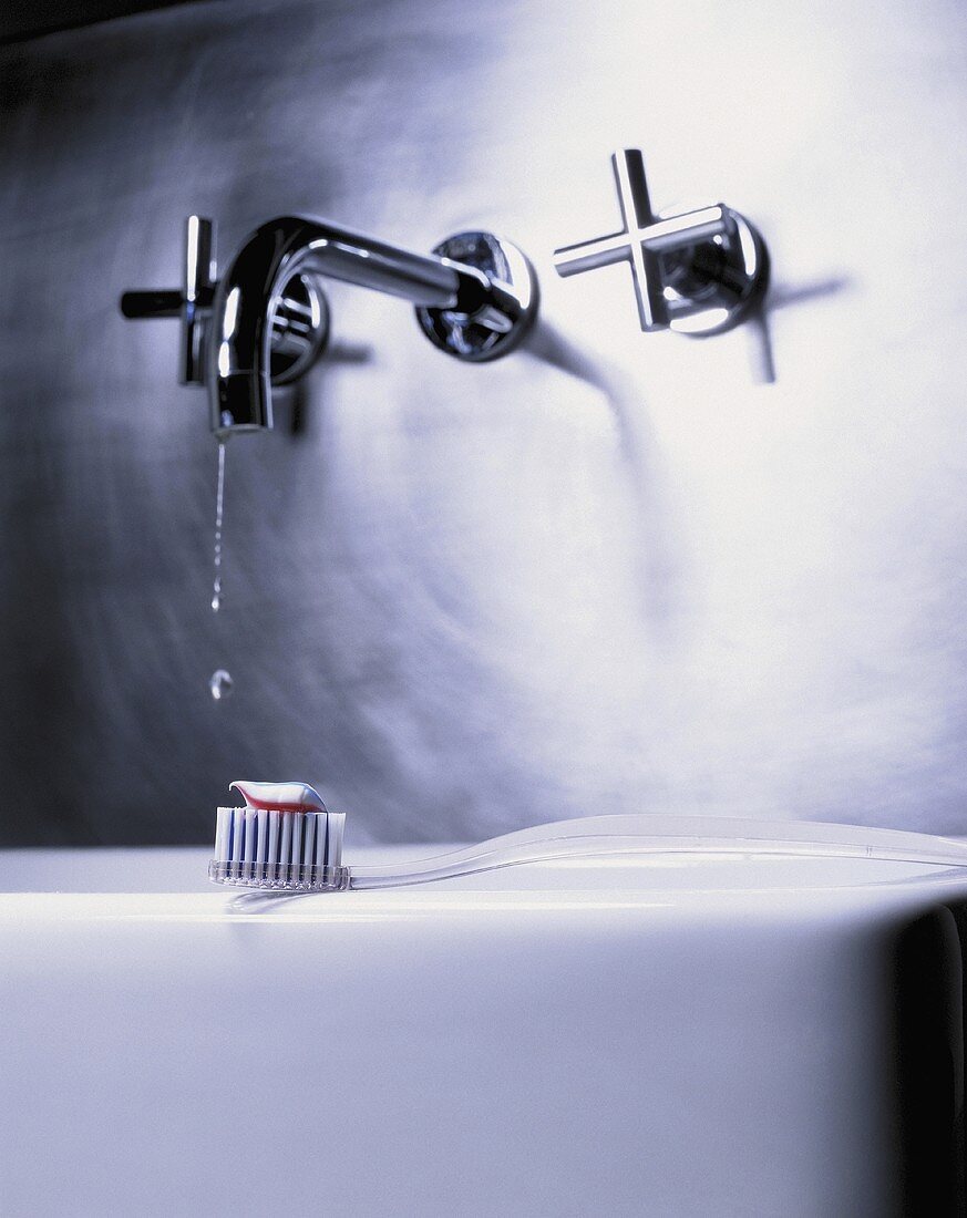 Modern taps and a toothbrush with toothpaste