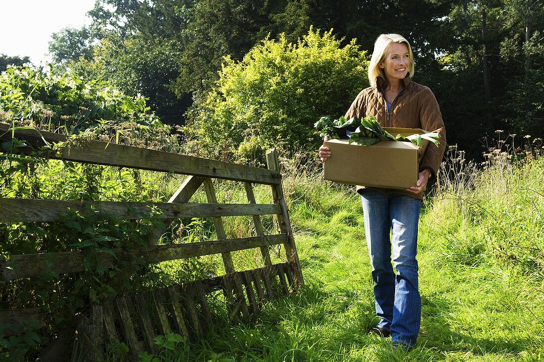 A woman holding box of plants