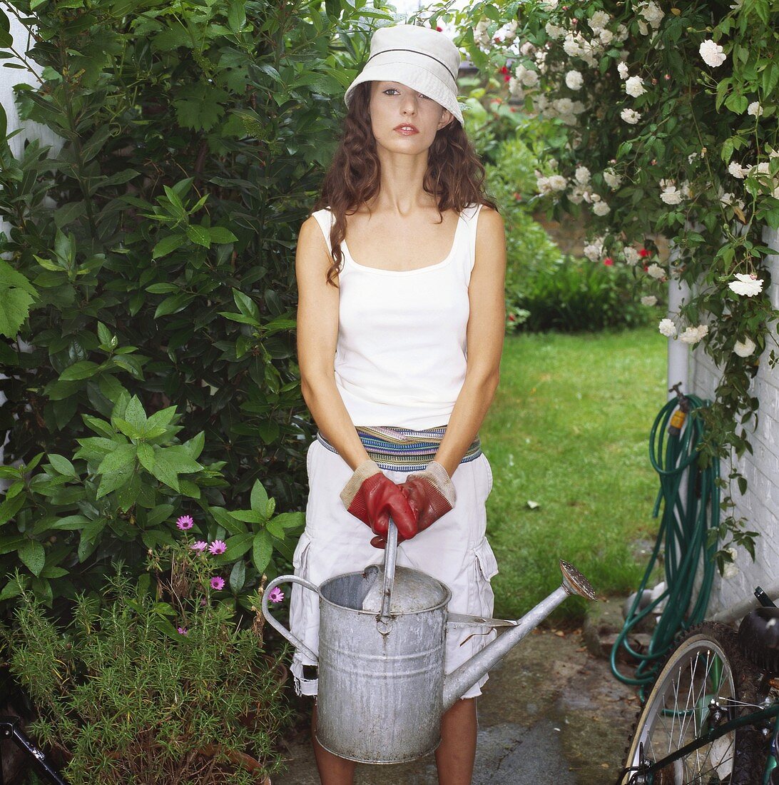 Frau mit Giesskanne in dem Garten