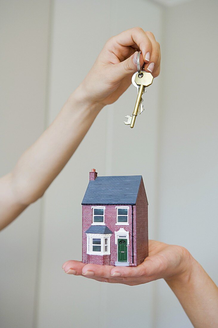 People holding keys and a house