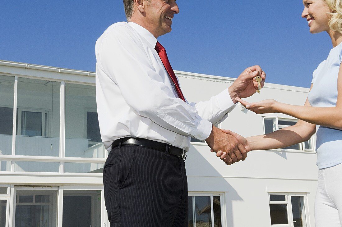 A woman and an estate agent shaking hands
