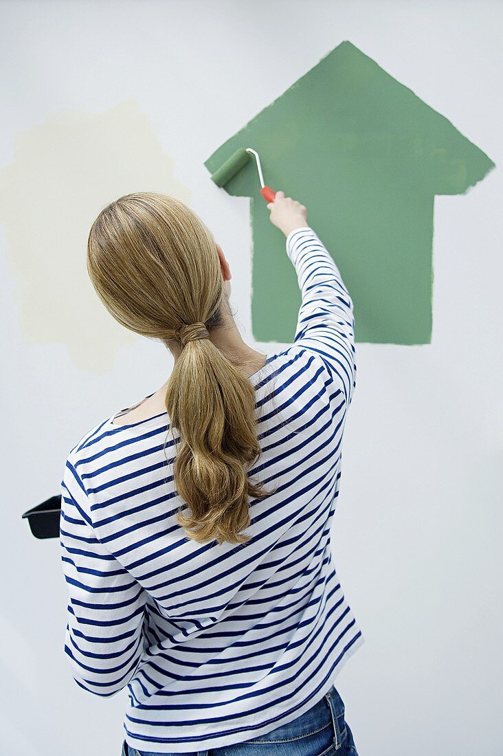 A woman painting a wall