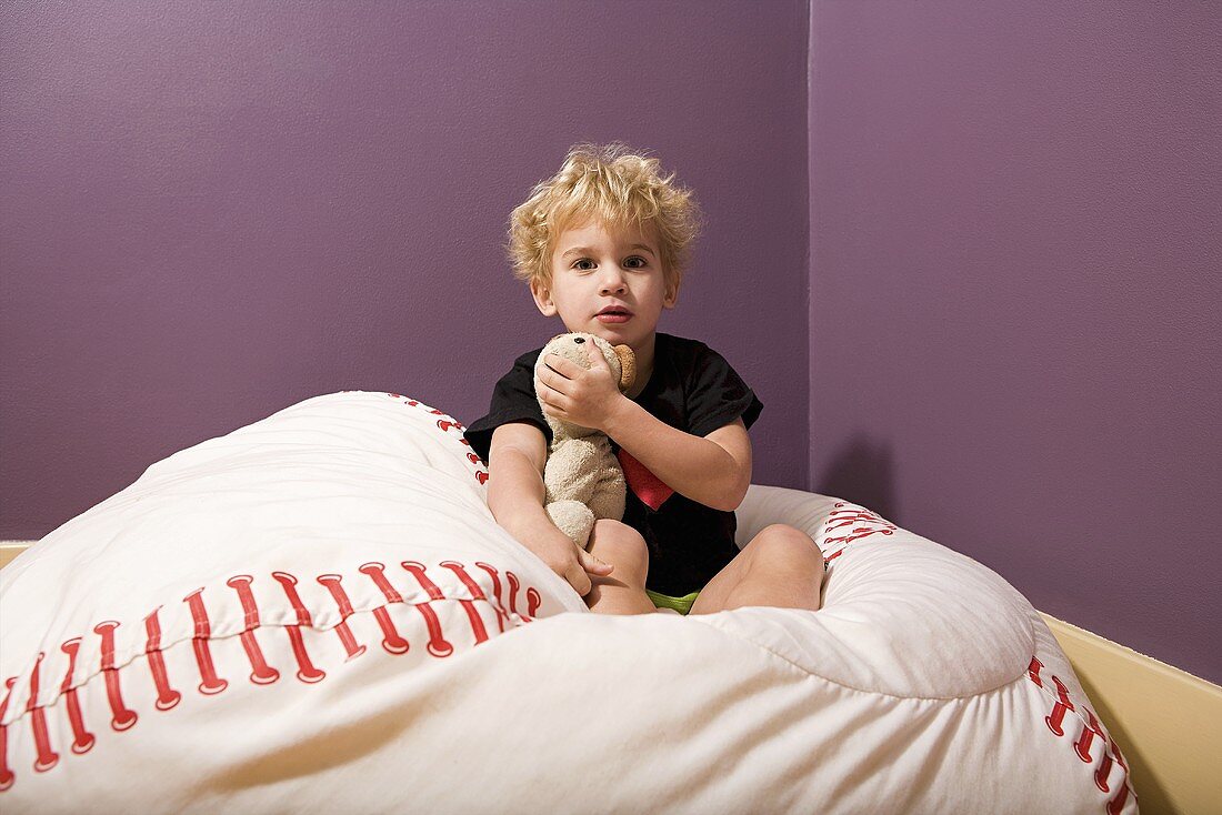 Junge im Bett mit Teddybär