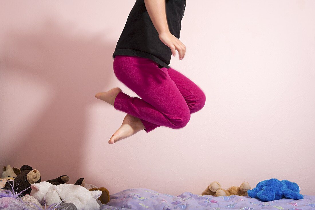 A child jumping on a bed