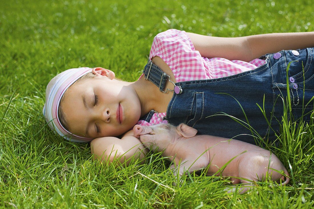 A girl and a piglet sleeping