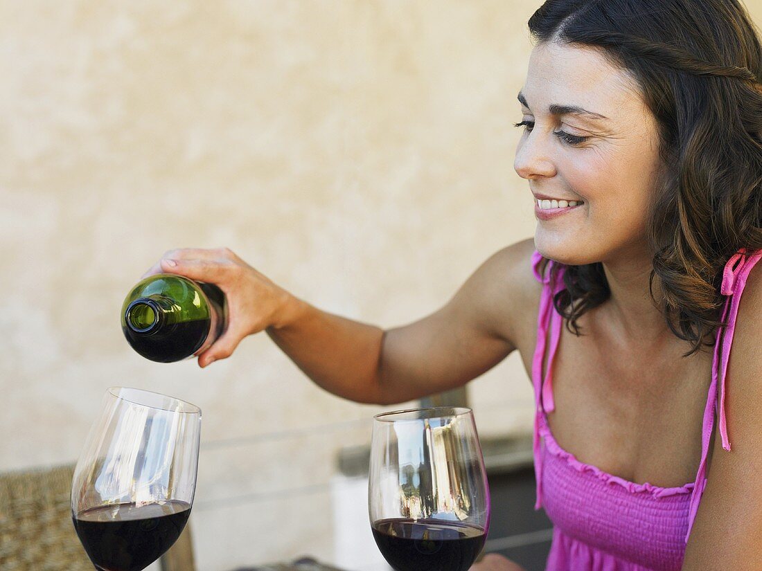A woman pouring red wine