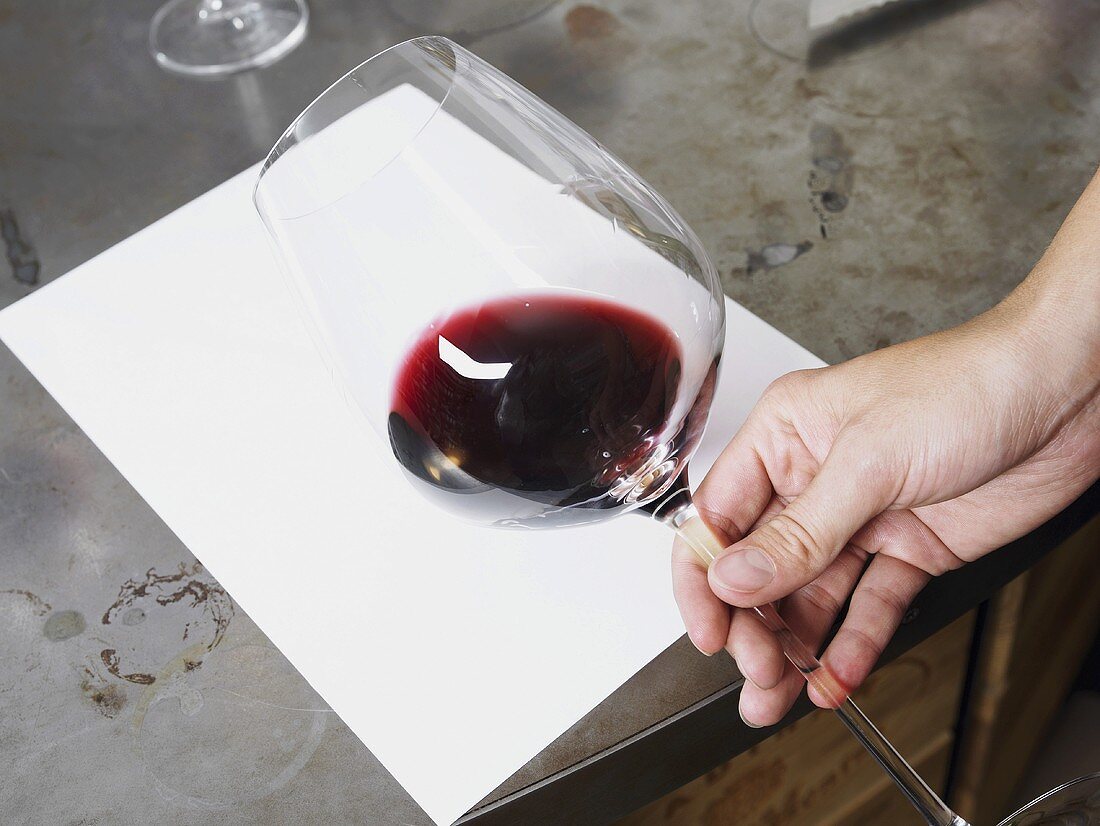 Checking the colour of red wine against white paper