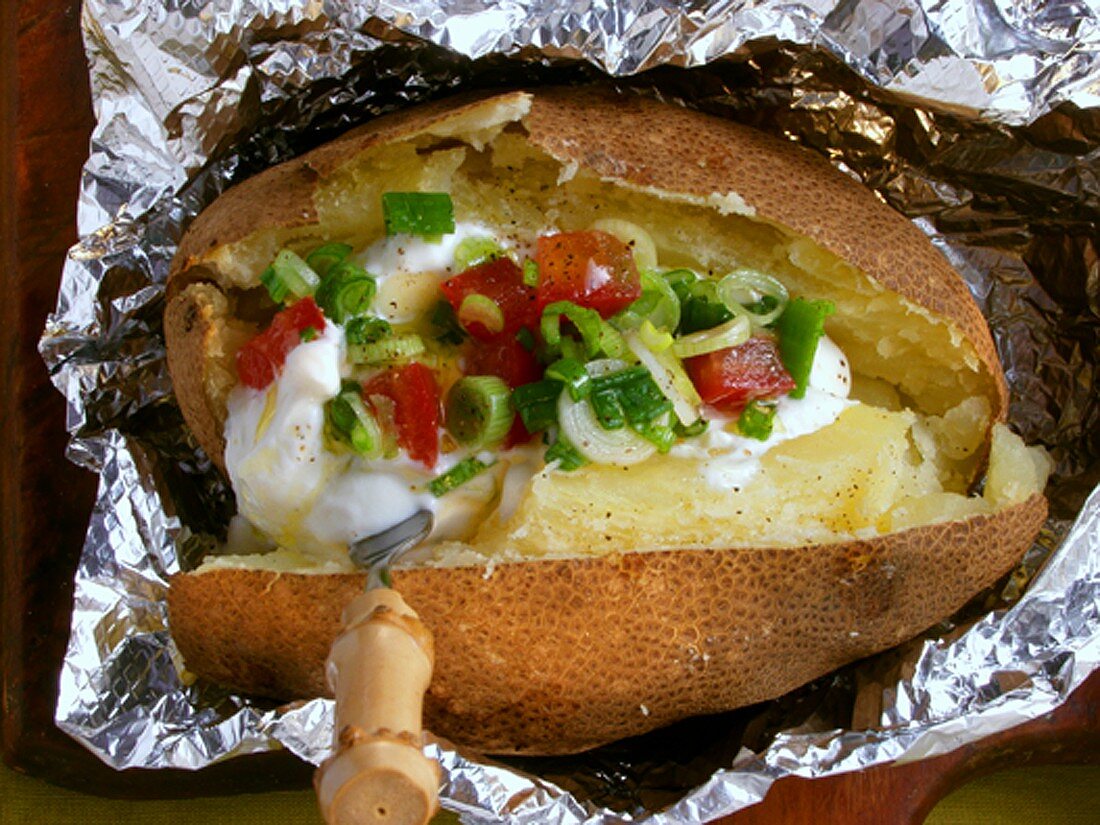 Baked potato with sour cream and spring onions