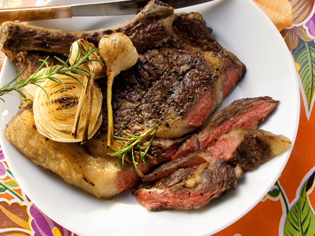 Barbecued ribeye steak with garlic, piece cut off
