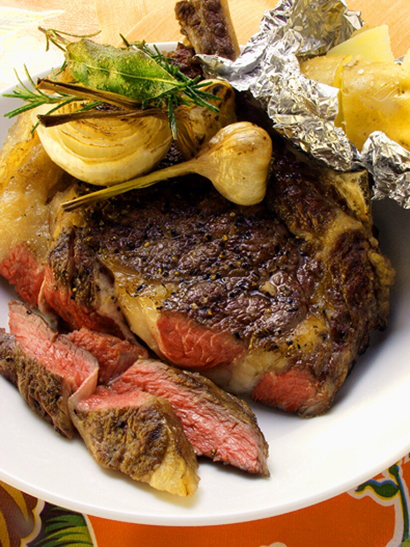 Gegrilltes Ribeye-Steak mit Knoblauch und Folienkartoffel