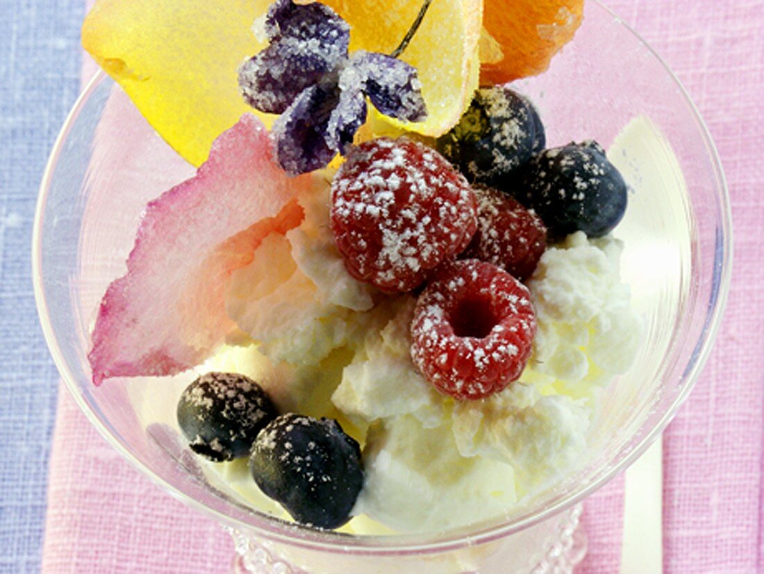 Quark dessert with berries and candied flowers