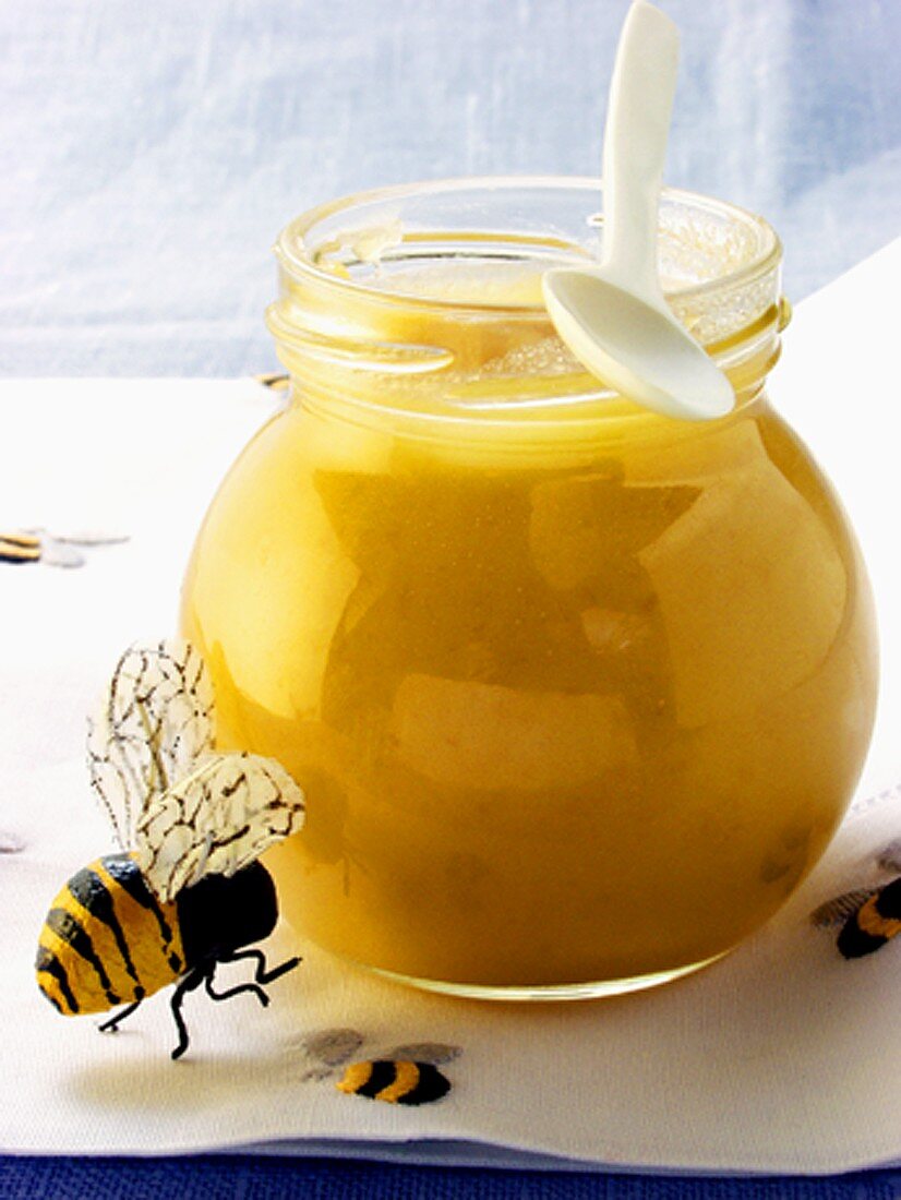 Blossom honey in jar with spoon; bee