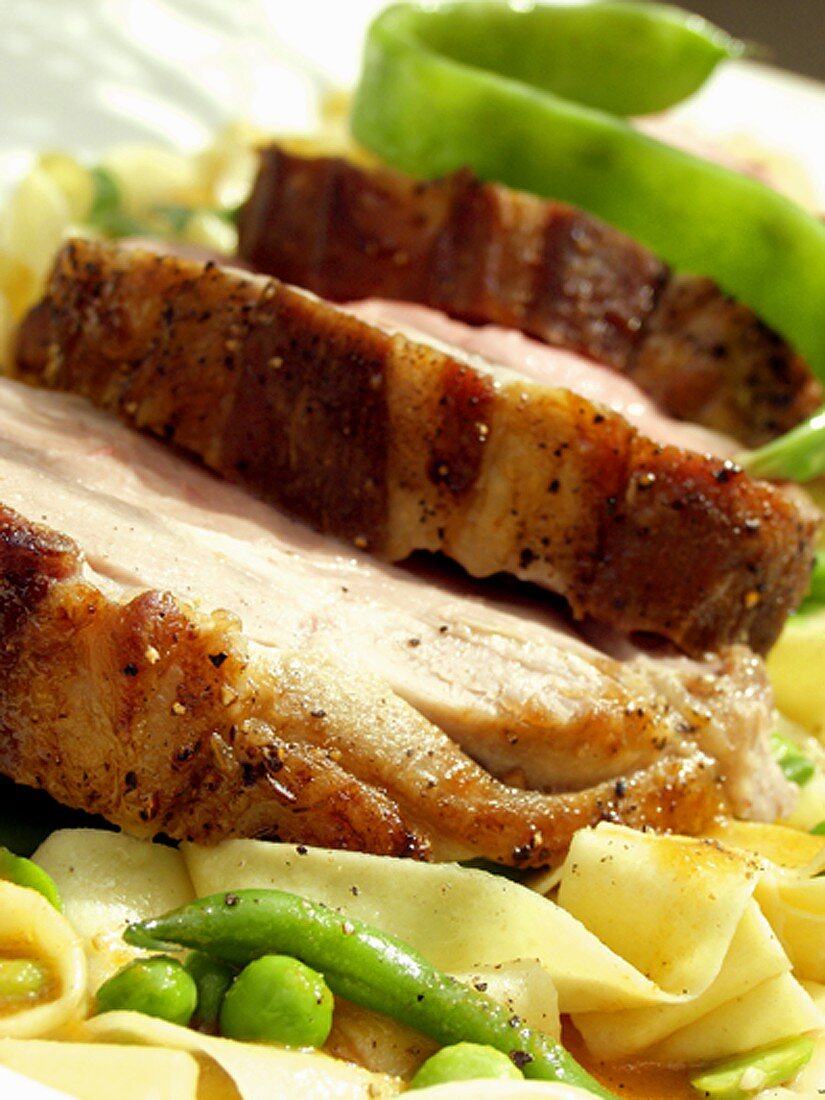 Roast pork with noodles, beans and peas