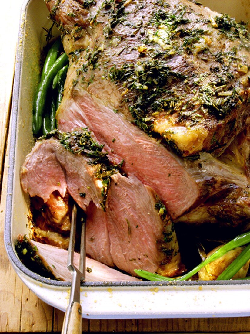 Leg of lamb with herbs in roasting dish