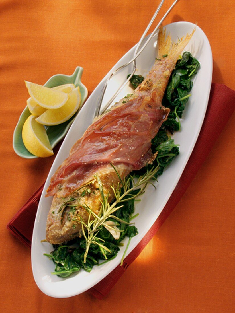 Red mullet with parma ham on spinach