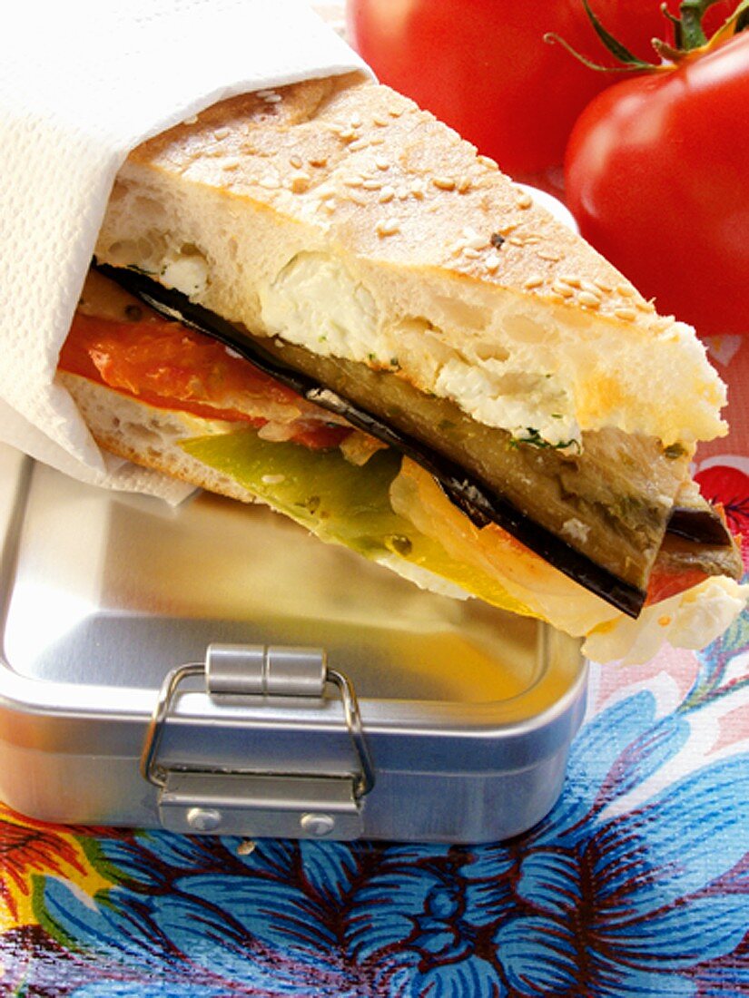 Sandwich with vegetables & cream cheese on lunch box; tomatoes
