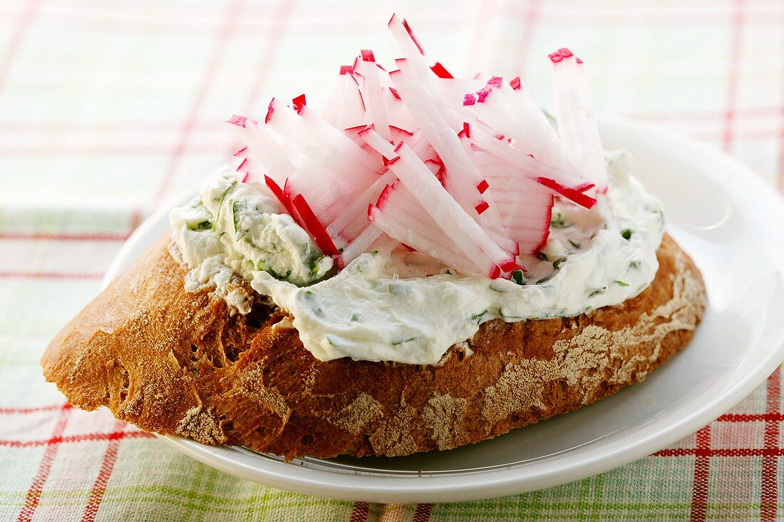 Belegtes Brot mit Kräuterquark und Radieschenstiften