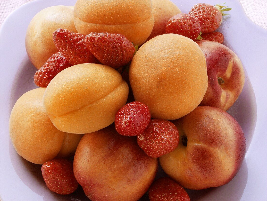 Fresh apricots, nectarines and strawberries on plate