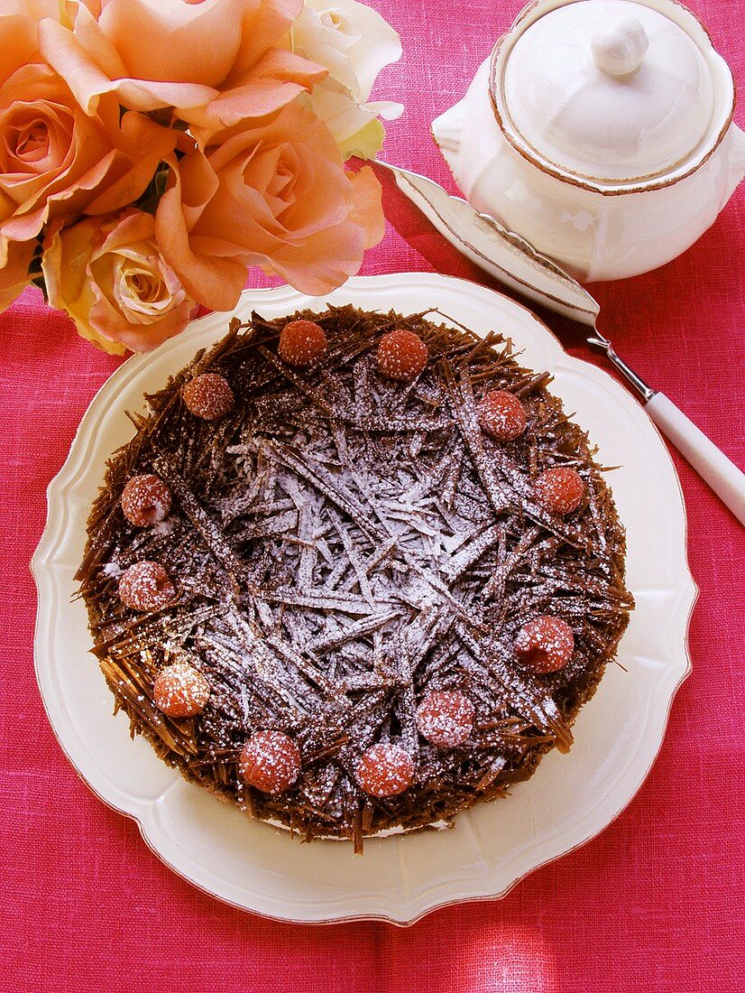 Schokoladen-Himbeer-Torte mit Puderzucker; Rosen; Zuckerdose