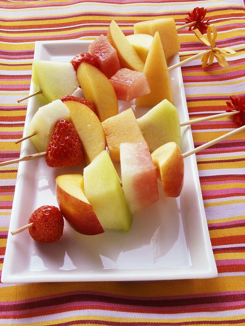 Colourful fruit kebabs on platter