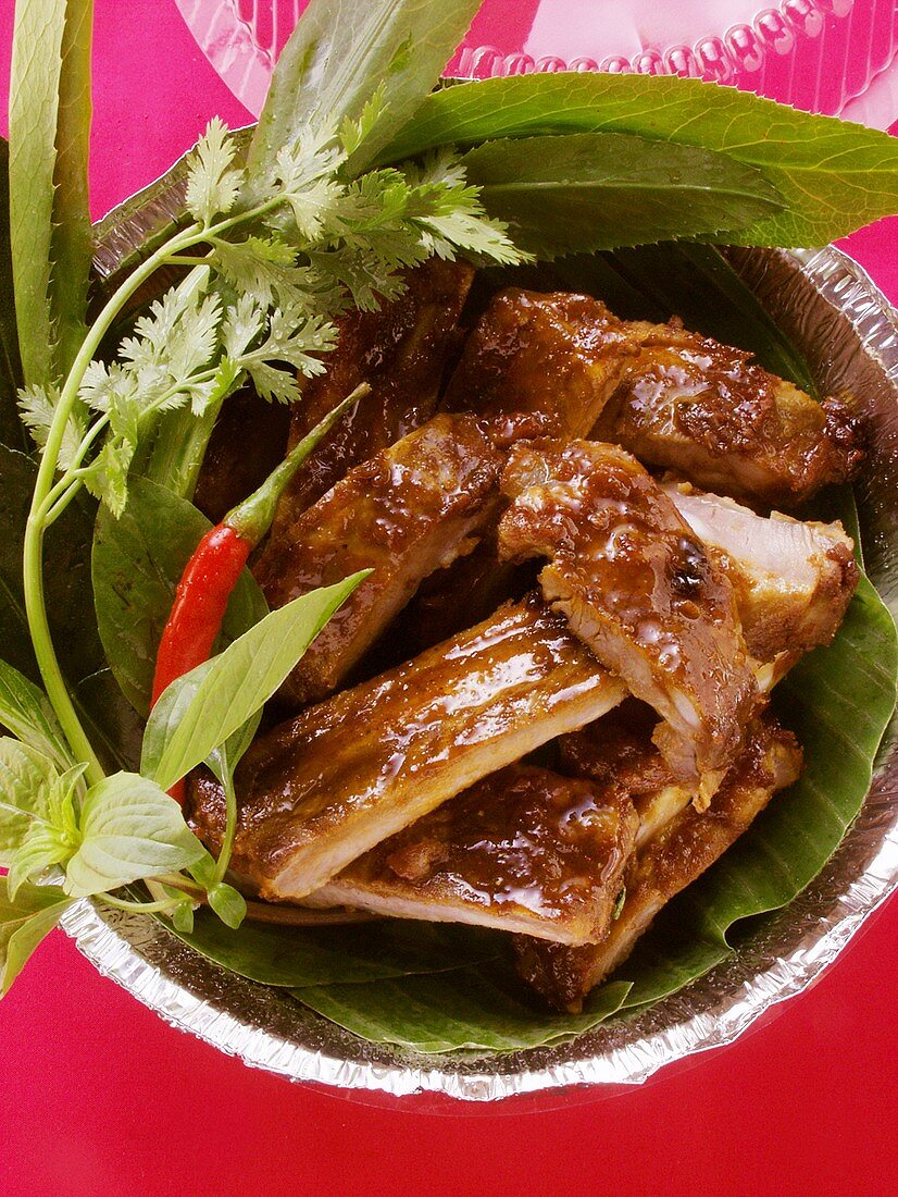 Crispy spare-ribs with fresh herbs in aluminium dish