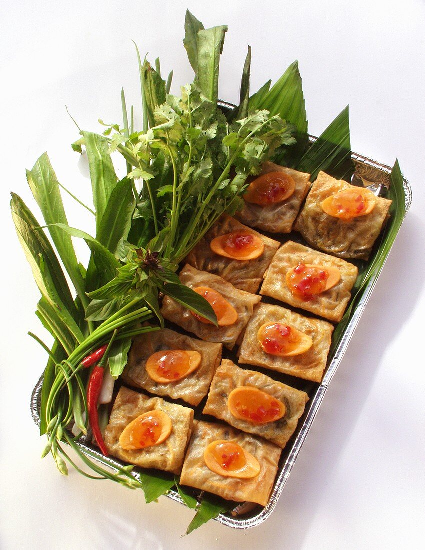 Spring rolls with carrots and herbs in aluminium dish