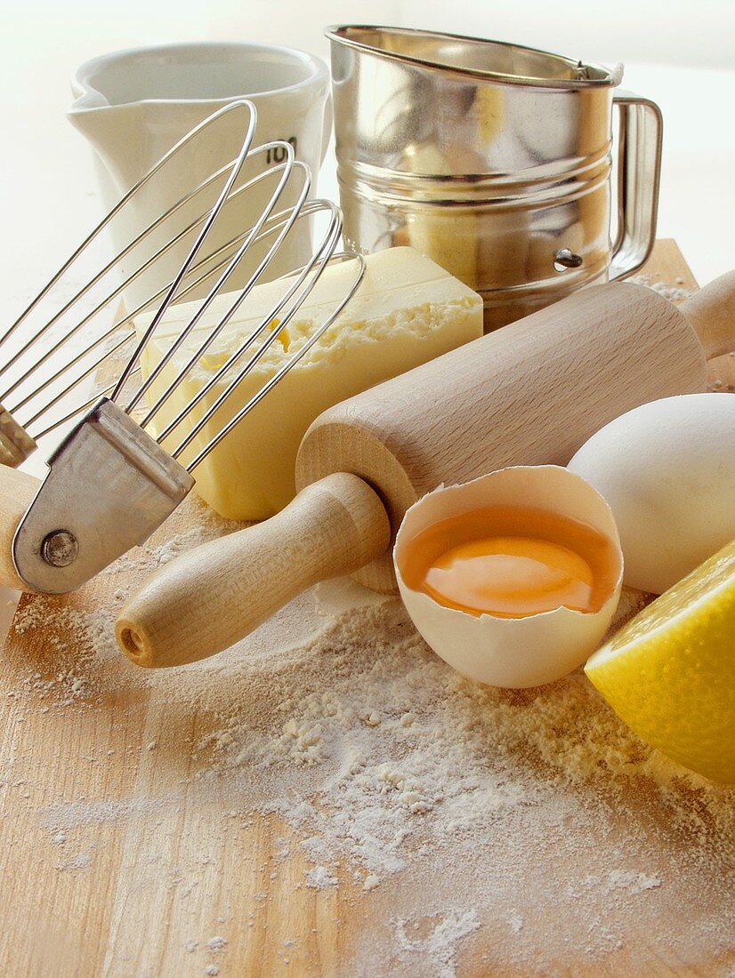 Various baking utensils, eggs, butter and lemon