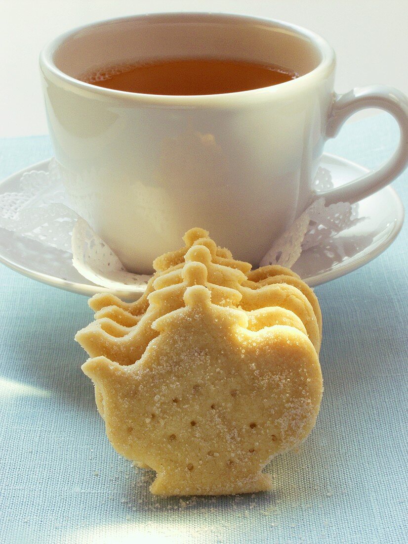 Plätzchen in Teekannenform vor Teetasse