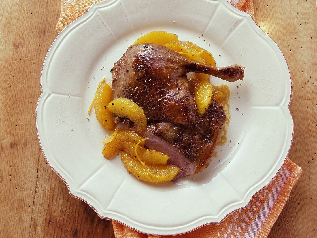 Duck with orange on white plate