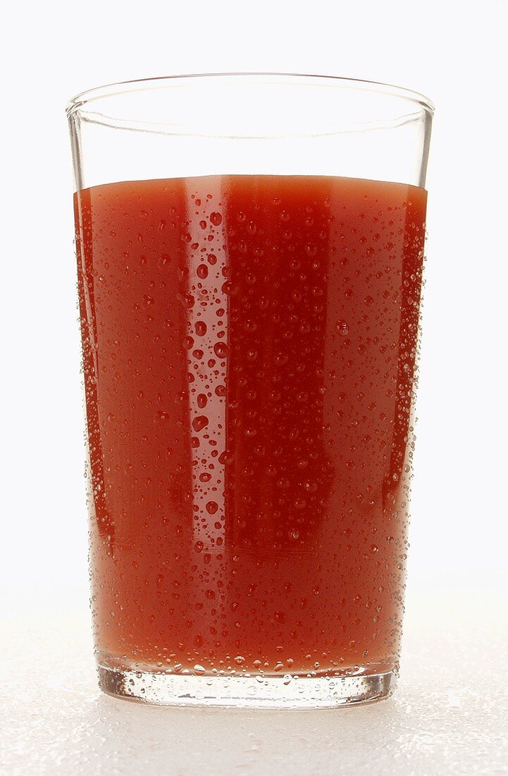 Tomato juice in glass with drops of water
