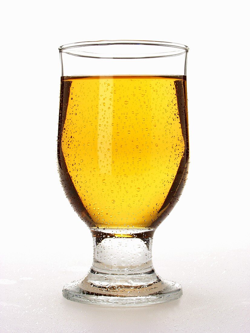 Glass of apple juice with drops of water