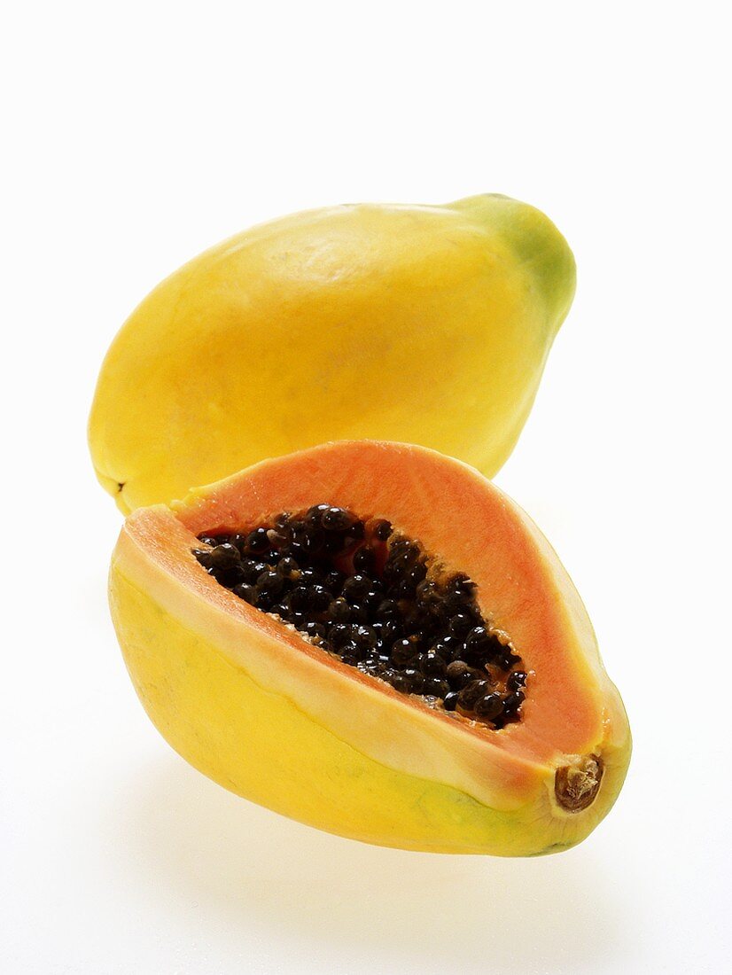 Two papayas, one with a piece cut off